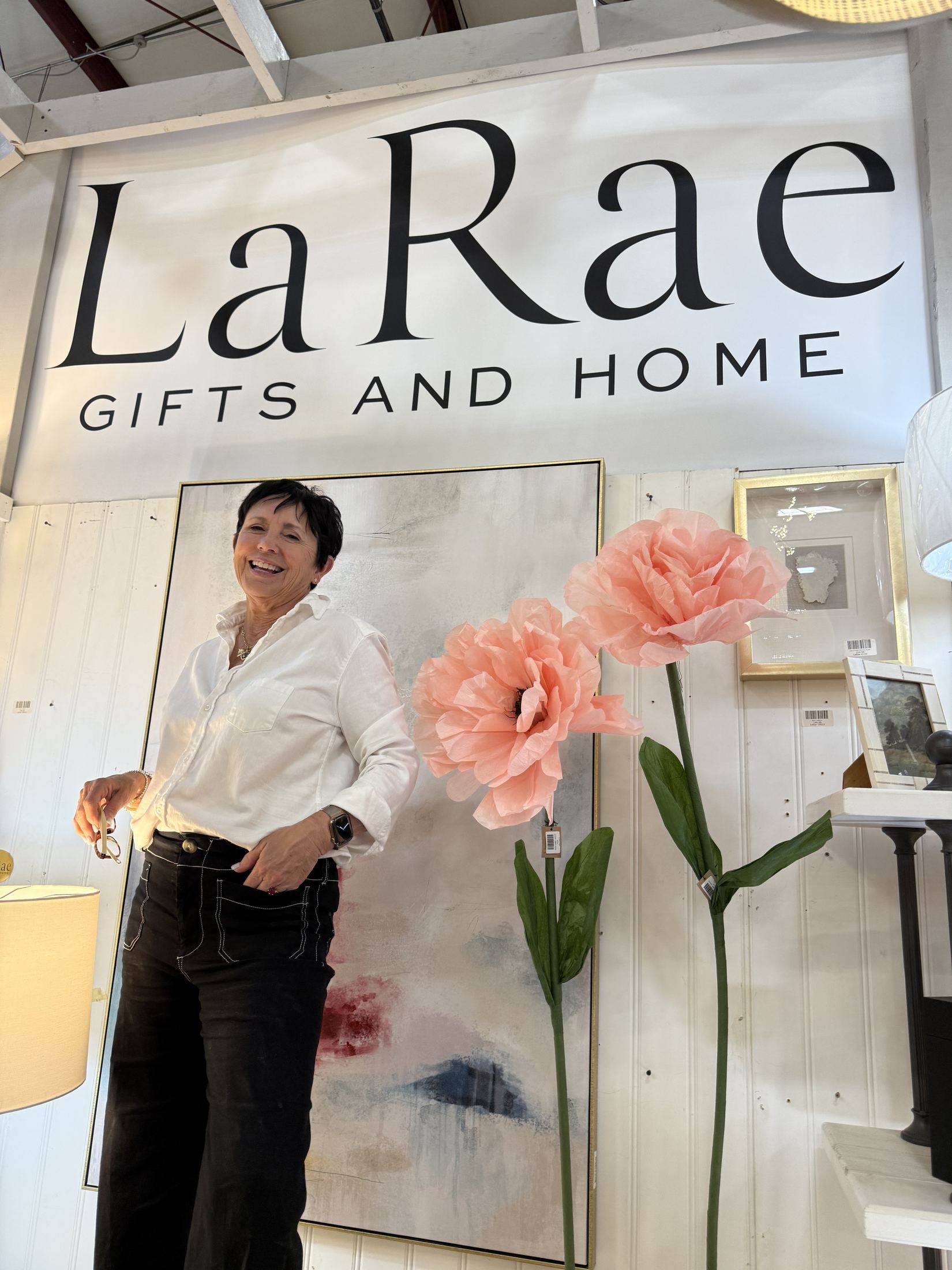 LaRae, owner of LaRae Gifts and Home, under the shop's sign in Clarksville, Tennessee.