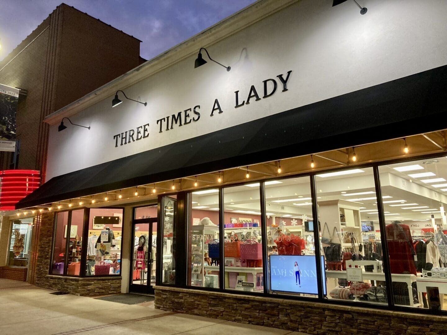 Three Times a Lady storefront lit up at dusk in Dickson, Tennessee.